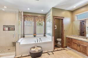 Bathroom with toilet, recessed lighting, vanity, a shower stall, and a bath