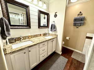 Primary Bathroom with ornamental molding, a sink, and wood finished floors