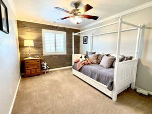 Carpeted bedroom 3 with crown molding, visible vents, wood walls, a textured ceiling, and ceiling fan