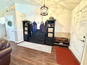 Foyer with lofted ceiling, stairway, baseboards, and a chandelier