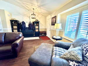 Living room featuring lofted ceiling, baseboards, and dark wood finished floors