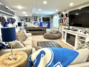 Living room with recessed lighting, light colored carpet, and a glass covered fireplace