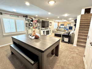 Game/Dining area featuring stairs, light carpet, and a healthy amount of sunlight