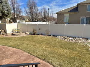 View of yard featuring an outdoor fire pit and a fenced backyard