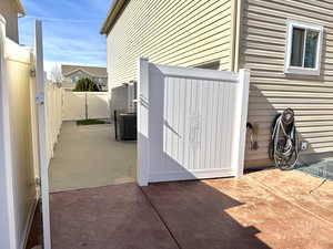 View of patio featuring a gate, fence, and central air condition unit