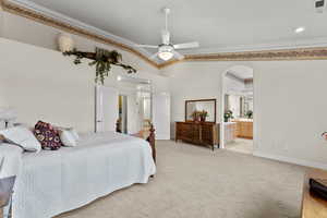 Bedroom featuring ornamental molding, light carpet, vaulted ceiling, and visible vents