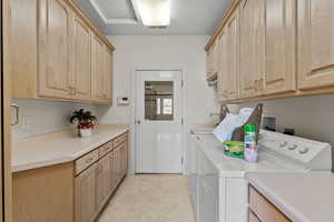 Washroom with cabinet space, light tile patterned floors, visible vents, a textured ceiling, and washing machine and dryer