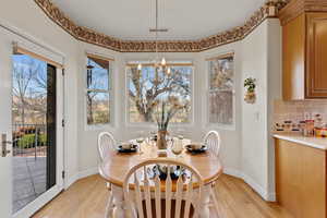 Dining room with light wood-type flooring, visible vents, a notable chandelier, and baseboards