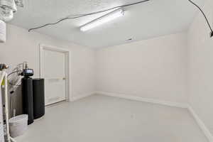 Basement featuring visible vents, baseboards, and a textured ceiling