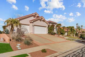 Mediterranean / spanish home with driveway, a tile roof, an attached garage, and stucco siding