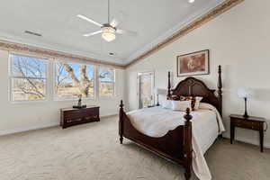 Bedroom featuring crown molding, visible vents, light carpet, vaulted ceiling, and baseboards