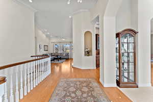 Interior space featuring baseboards, ceiling fan, light wood-style flooring, and crown molding