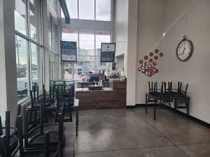 Interior space featuring baseboards, visible vents, a towering ceiling, and finished concrete floors