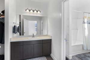 Bathroom featuring wood finished floors, vanity, and baseboards