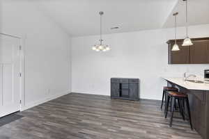 Interior space with visible vents, a peninsula, light countertops, a kitchen bar, and a sink