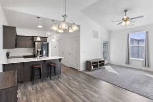 Kitchen with visible vents, open floor plan, decorative light fixtures, light countertops, and stainless steel refrigerator with ice dispenser