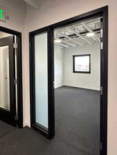 Unfurnished room featuring dark carpet and baseboards