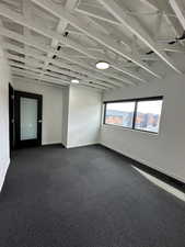 Unfurnished room with dark carpet and baseboards