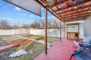 Deck with a shed, an outdoor structure, a fenced backyard, and a pergola