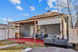 Rear view of property with a chimney, a wooden deck, and fence