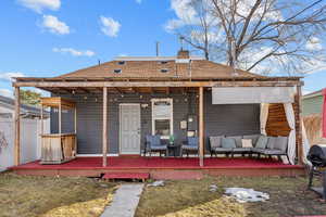 Rear view of house with a chimney, fence, a deck, and an outdoor hangout area