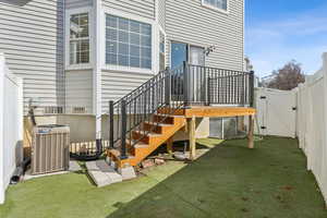 Property entrance featuring a gate, fence, a lawn, and central AC unit