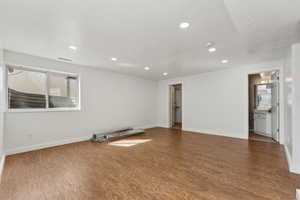 Empty room with recessed lighting, wood finished floors, visible vents, baseboards, and plenty of natural light