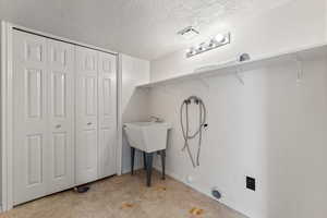 Laundry room featuring laundry area, visible vents, baseboards, a textured ceiling, and washer hookup