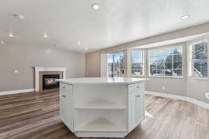 Kitchen with open shelves, white cabinetry, and a center island