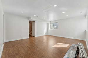 Spare room with stairs, recessed lighting, baseboards, and wood finished floors