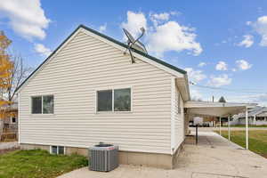 View of property exterior with a carport, a yard, and covered porch