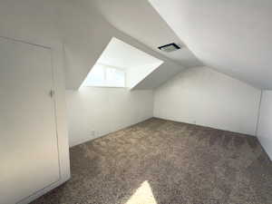 Bonus room featuring lofted ceiling and carpet flooring