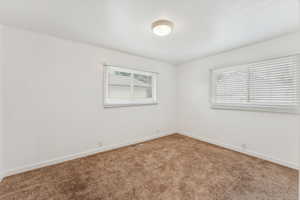 Unfurnished room featuring carpet and plenty of natural light