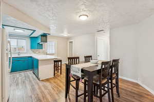 Dining room featuring light wood finished floors and a textured ceiling