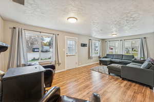 Living room featuring light wood-style floors and a textured ceiling