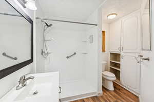 Bathroom featuring dark wood-style floors, a stall shower, vanity, and a textured ceiling