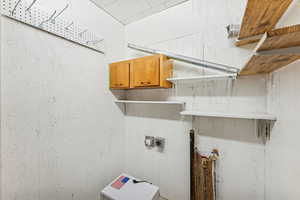 Washroom with hookup for an electric dryer, hookup for a washing machine, and cabinet space