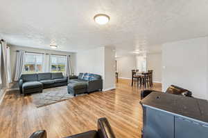 Living area featuring light wood-style floors and a textured ceiling