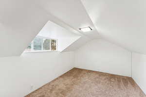 Additional living space with carpet and lofted ceiling