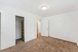 Unfurnished bedroom featuring carpet and a closet