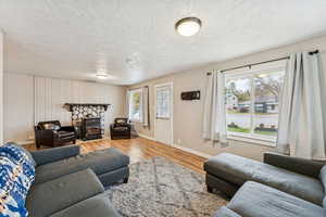 Living room featuring light wood-style flooring and a textured ceiling