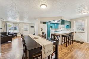 Dining space featuring light wood-type flooring and a textured ceiling