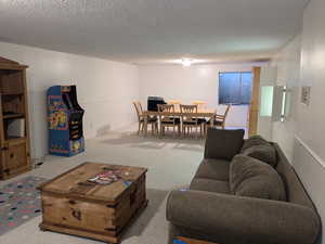 Living area featuring a textured ceiling and light colored carpet