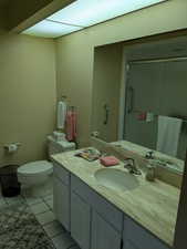 Bathroom featuring toilet, tile patterned flooring, and vanity