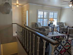 Interior space featuring ornamental molding and an upstairs landing