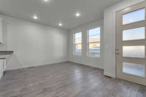 Interior space with baseboards, wood finished floors, and recessed lighting