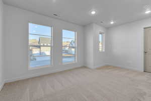 Spare room featuring light carpet, baseboards, visible vents, and recessed lighting