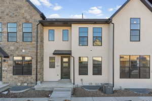 Multi unit property with stone siding, central AC unit, and stucco siding