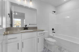 Bathroom with marble finish floor, visible vents, toilet, tub / shower combination, and vanity