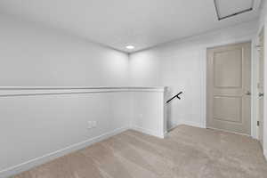 Spare room with baseboards and light colored carpet